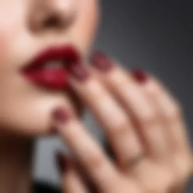 Close-up of a hand applying burgundy red nail polish