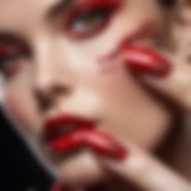 A close-up of a glossy red manicure with artistic embellishments