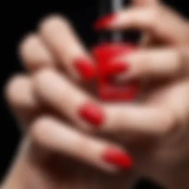 Close-up of a hand applying red nail polish with precision and elegance.