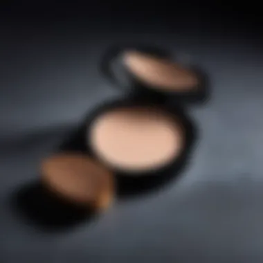 A close-up of a makeup powder compact with a soft brush beside it.