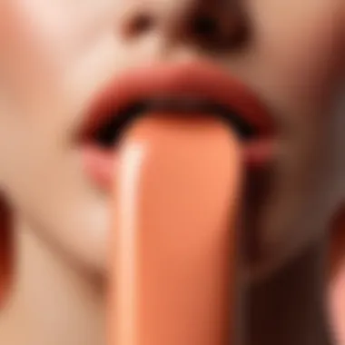 A close-up of a peach-hued lipstick tube showcasing its creamy texture